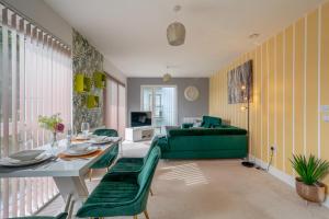 ein Wohnzimmer mit einem grünen Sofa und einem Tisch in der Unterkunft LillyRose Apartments - Hemel Hempstead, Free Parking, Free Wi-Fi in Kings Langley
