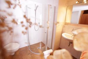 e bagno con doccia, servizi igienici e lavandino. di Berggasthaus Weingarten a Ruhpolding