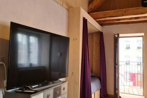 een flatscreen-tv in een kamer met een raam bij Petit bijou de Sainte-Croix in Sainte-Croix