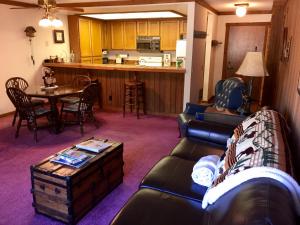 a living room with a couch and a table and a kitchen at Mountainback #74 in Mammoth Lakes