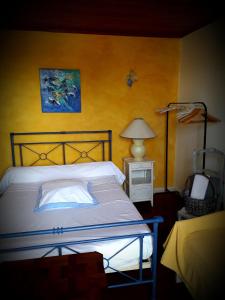 a bedroom with a bed and a yellow wall at B&B chez Annie in Saint-Martin-de-Gurçon