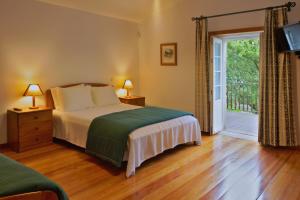 - une chambre avec un lit et une porte coulissante en verre dans l'établissement Casa da Aldeia, à Sever do Vouga