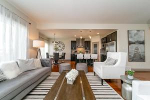 uma sala de estar com um sofá e uma mesa em Lakeview Luxury Home - Double Garage Parking - Foosball Table - King Beds - Fast Wi-Fi -Free Netflix em Edmonton