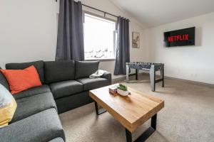 uma sala de estar com um sofá e uma mesa em Lakeview Luxury Home - Double Garage Parking - Foosball Table - King Beds - Fast Wi-Fi -Free Netflix em Edmonton
