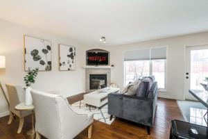 a living room with a couch and a fireplace at Chic 4 BDRM Home I King Bed I Double Garage Parking & Fast WiFi! in Edmonton