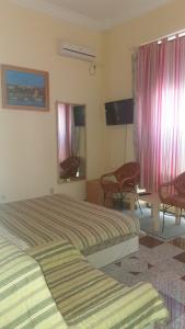 Habitación de hotel con 2 camas, mesa y sillas en Vila club 011, en Dedinje