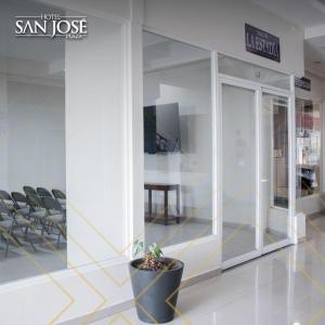 um lobby com uma planta em vasos no meio de um edifício em Hotel San José Plaza Coatepec em Coatepec