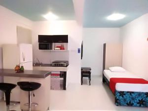 een kleine kamer met een bed en een keuken bij Apartamentos Chuchos Place in San Andrés