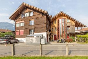 a large wooden house with a car parked in front of it at Mohn in Interlaken