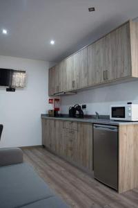 - une cuisine avec des placards en bois et un comptoir dans l'établissement O Salgueiro, à Melo