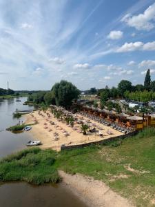 a beach with chairs and umbrellas next to a river at Hotel Brückentor in Rinteln
