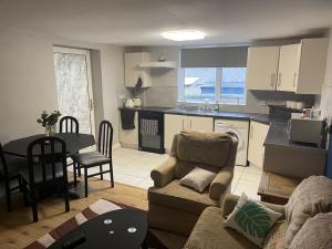 a kitchen and living room with a couch and a table at Login house A in Derry Londonderry