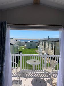 a patio with a table and chairs on a deck at 6 Swan View Haven, Littlesea in Weymouth