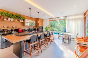 プライア・ド・フォルテにあるPF17 Casa Alto Padrão 5 Suítes, Chefe de Cozinha Inclusa - Praia do Forteのバースツール付きの大きな島のあるオープンキッチンが備わります。