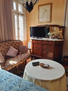 een woonkamer met een tv en een bank en een tafel bij Casa dos Leones in Santiago