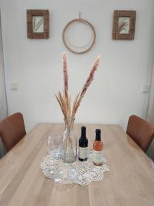a table with two bottles and a vase with flowers at Urlaub mitten in Markelsheim in Bad Mergentheim