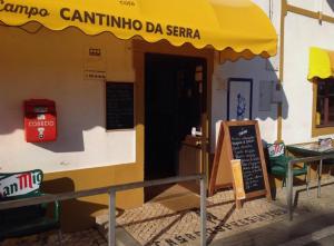 ein Restaurant mit gelbem Regenschirm und Schild in der Unterkunft Casa De Campo Cantinho Da Serra in Cortelha