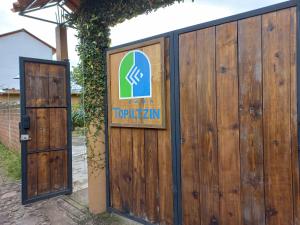 a sign on a wooden fence next to a door at Posada Casa Topiltzin in Tepoztlán