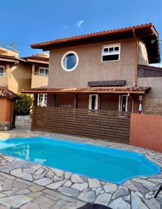 a swimming pool in front of a house at Sol Mar in Praia do Rosa