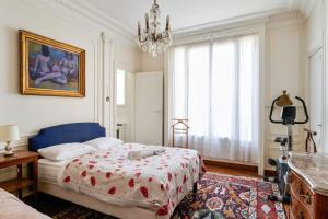 - une chambre avec un lit et un lustre dans l'établissement Superb flat two steps away from Porte Maillot in Paris - Welkeys, à Paris