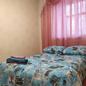 a bed with a comforter and pillows on it at Apartments of 4 S.K.D in Sumy