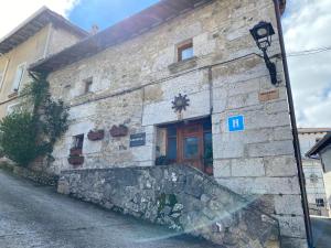 a stone building with a wooden door on a street at Casa Rural Edronekoa Ideal PAREJAS in Unanu