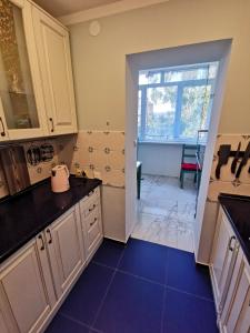 a kitchen with white cabinets and a blue tile floor at Апартаменты в Абхазии, г Сухуми пос Агудзера in Sukhum