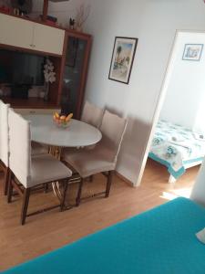 - une salle à manger avec une table, des chaises et un lit dans l'établissement Apartman Milena, à Korčula