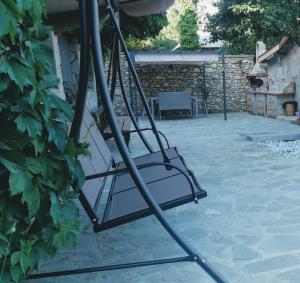 a swing seat on a patio with a stone wall at Apartment Bankya in Bankya +16 photos