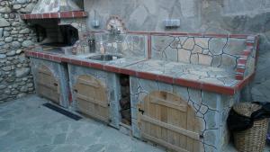 an outdoor kitchen with a sink and a stone wall at Apartment Bankya in Bankya
