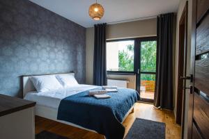 1 dormitorio con cama y ventana grande en Bazalt Apartments, en Miercurea-Ciuc