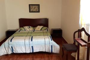 1 dormitorio con 1 cama y 1 silla en Alojamiento Esmeralda Azul, en Armenia