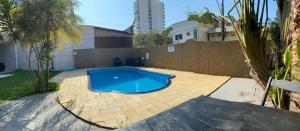 a large blue swimming pool in a backyard at Casa Mansão em Cabeçudas in Itajaí