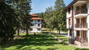 un edificio de apartamentos con un patio con árboles en Studio by Mountain Lakes, en Ezerovo