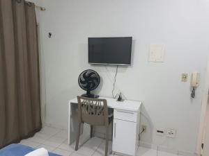 a desk with a chair and a television on a wall at Asa Norte in Brasilia +9 photos