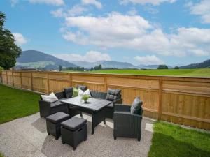 a patio with a table and chairs and a fence at Haus Leo in Westendorf