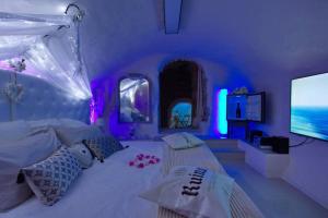 Habitación púrpura con cama y TV de pantalla plana. en Les Secrets d'Alcôve, nuits Romantiques avec SPA, en Aix-en-Provence