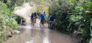 a group of people riding bikes through a stream at Hostel Casa de Nelly in San Agustín +50 photos