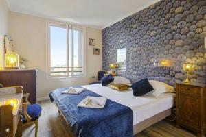 sypialnia z 2 łóżkami i kamienną ścianą w obiekcie Flat with terrace and incredible view in Biarritz - Welkeys w Biarritz