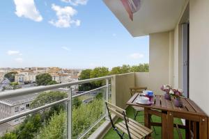 a balcony with a table and a view of a city at Flat with terrace and incredible view in Biarritz - Welkeys in Biarritz