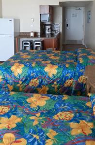 a room with a bed, table, and chairs at Daytona Beach Hawaiian Inn in Daytona Beach