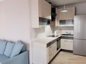 a kitchen with white cabinets and a white refrigerator at Apartament Ania in Świnoujście