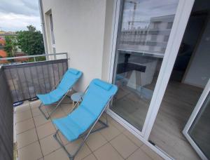 two blue chairs on a balcony with a view at Apartament Ania in Świnoujście