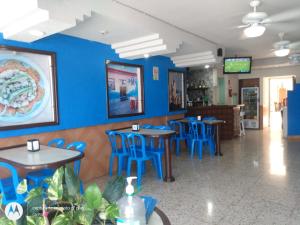 a restaurant with blue walls and tables and blue chairs at Hotel Atlantico a 150 mts de Playa Martí in Veracruz