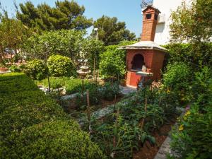 einen Garten mit einem Backsteinofen in der Mitte in der Unterkunft Villa Neda in Makarska