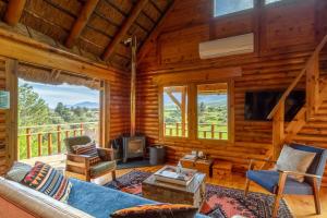 a log cabin living room with a couch and a tv at Tulbagh Mountain Cabin in Wolseley