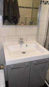 La salle de bains est pourvue d'un lavabo blanc et d'un miroir. dans l'établissement Studio les 2 Aples, à Les Deux Alpes