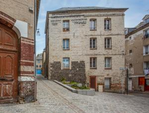 an old brick building on a street in an alley at El arco iris entre port et plage in Dieppe
