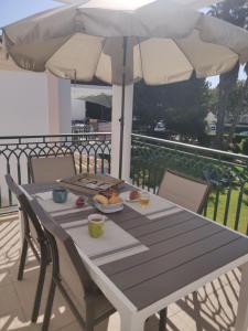 une table avec une assiette de nourriture et un parapluie dans l'établissement Algarve Albufeira, quiet apart with pool at 10 mn walk from Praia da Falesia, à Olhos de Água