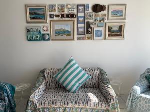 a living room with a couch and pictures on the wall at Paradise On the Bay in Fish hoek